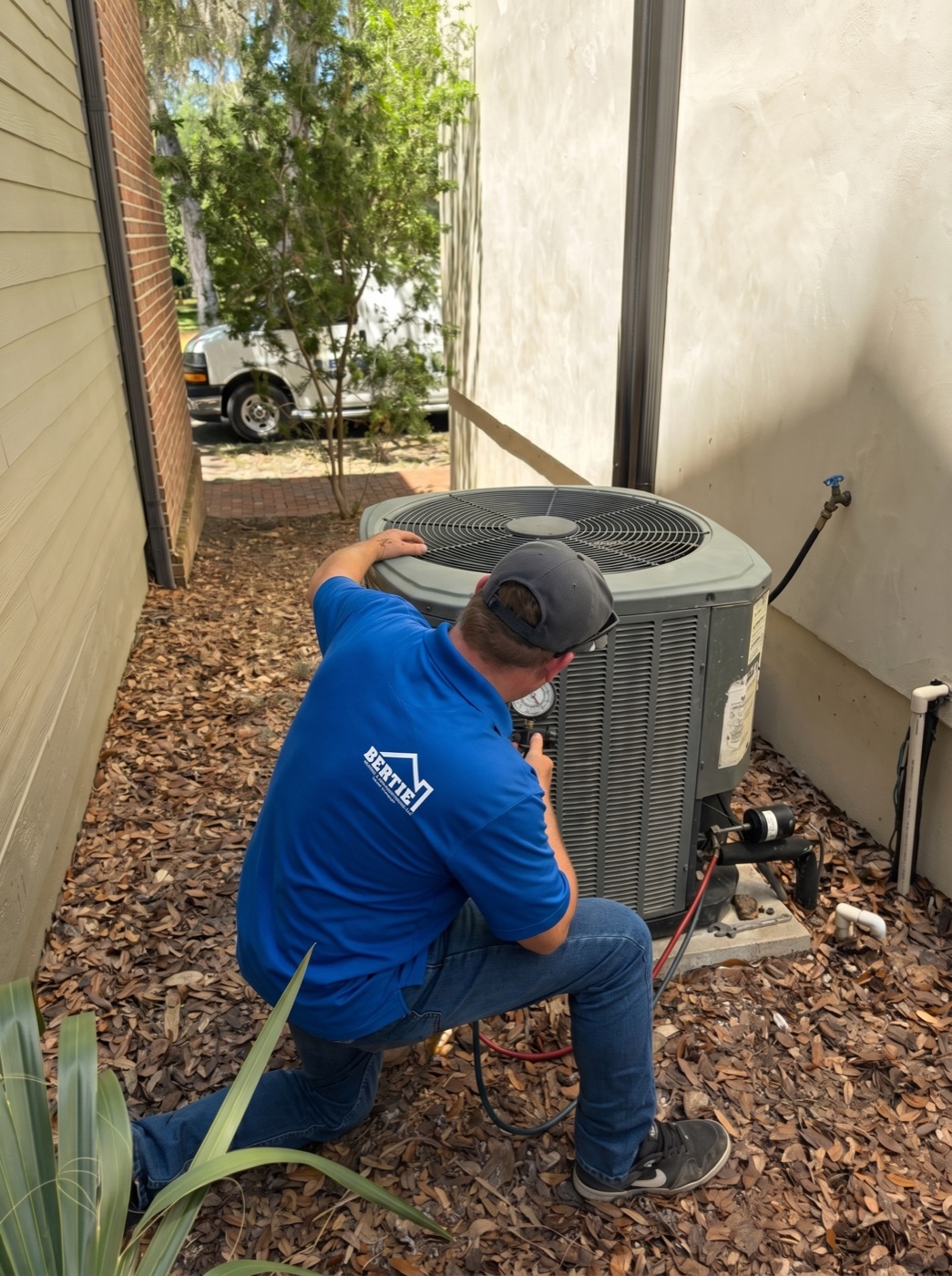 Bertie Air technician servicing a high-efficiency outdoor AC unit at a Gainesville home